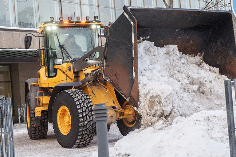 Gul dumper jobber og måker snø
