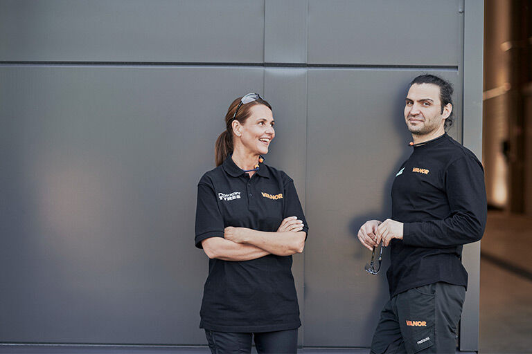 Två servicemekaniker från Vianor står framför en Vianor-anläggning