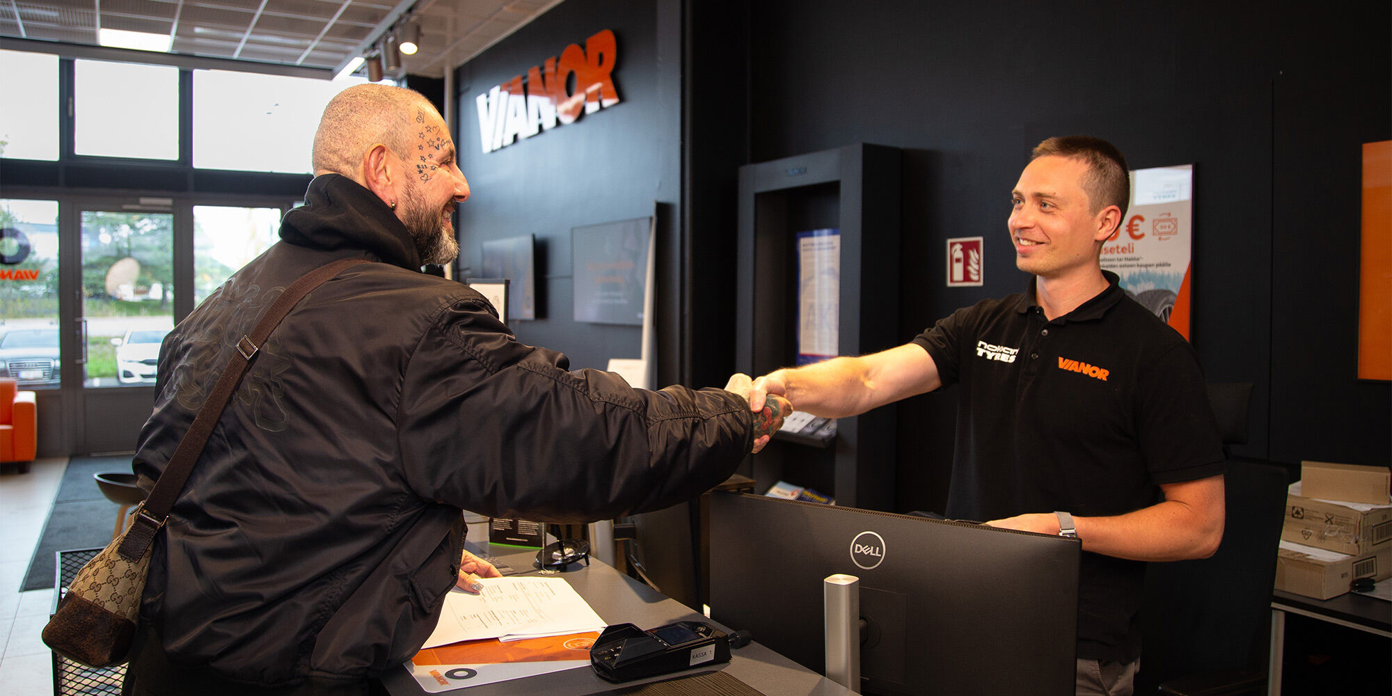 Vianorin asiantuntija antamassa auton avaimia tyytyväiselle asiakkaalle.