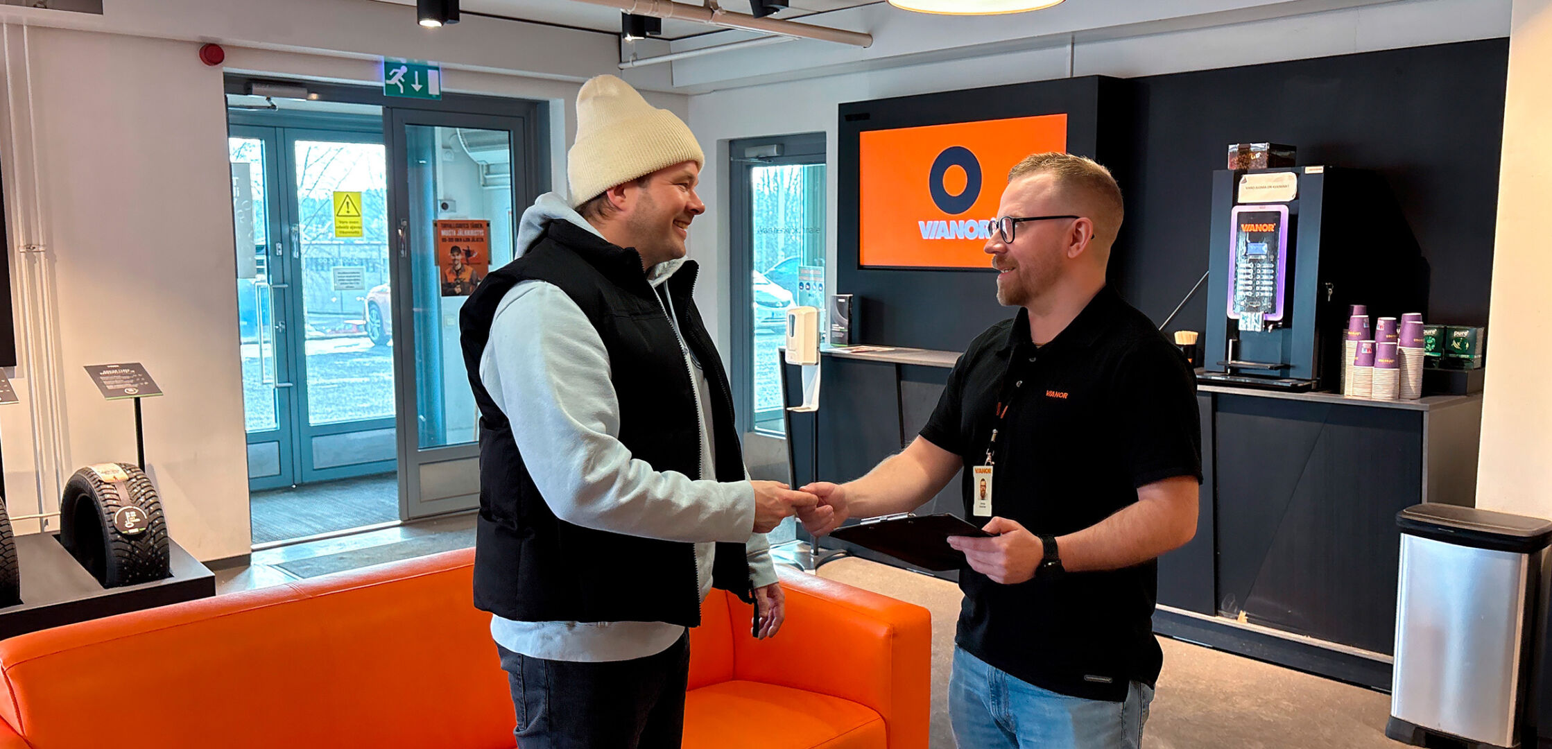 Tyytyväinen asiakas kättelee Vianorin palveluneuvojaa Vianor-palvelupisteessä.