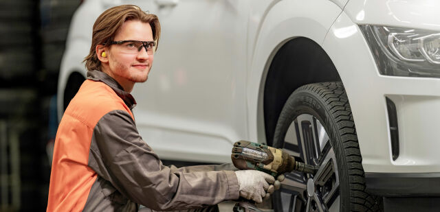 Vianorin asiantuntija vaihtamassa renkaita sähköautoon