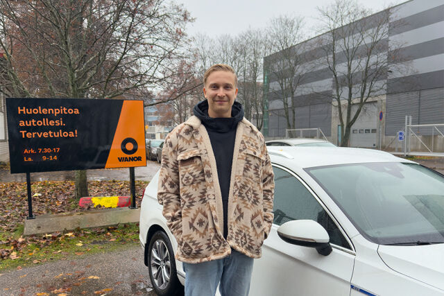 Mies seisomassa autonsa edessä ulkona