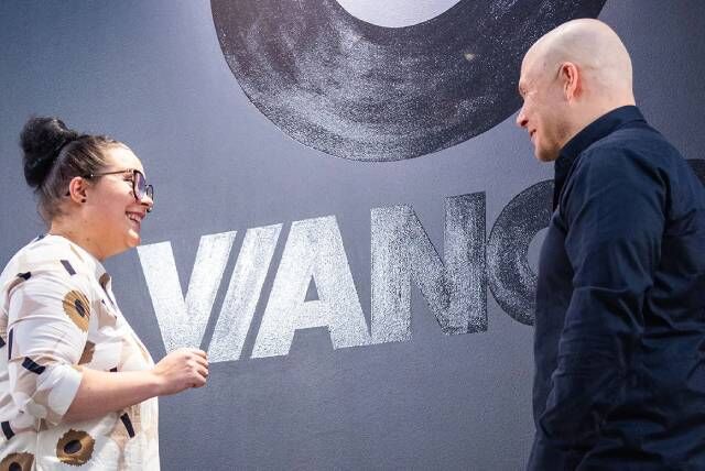 Nainen keskustelemassa myyjän kanssa 