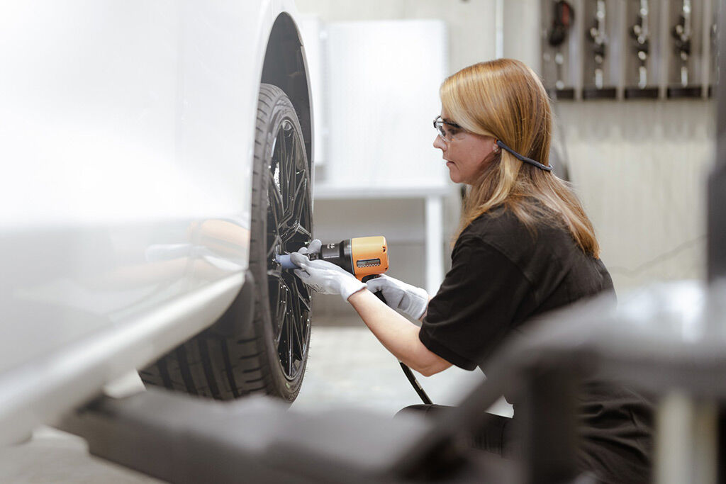 Henkilö istumassa oranssilla sohvalla uudenaikaisessa Vianorin odotustilassa, jossa on mustat seinät, valkoisia tiiliyksityiskohtia ja Vianorin brändijulisteita seinällä.