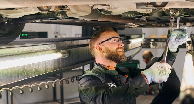 Mechanic doing car service under the car
