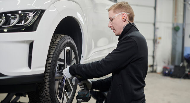 Vianorin ammattilainen vaihtamassa auton rengasta sähköautoon
