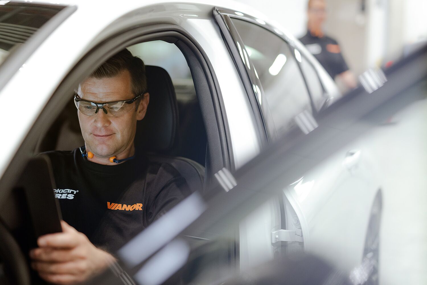 Bilmekaniker sitter i bilen og leser av OBD