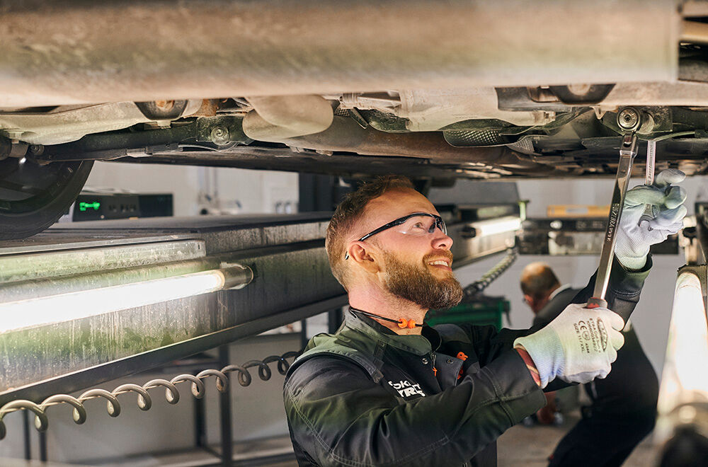 Bilmekaniker under en bil