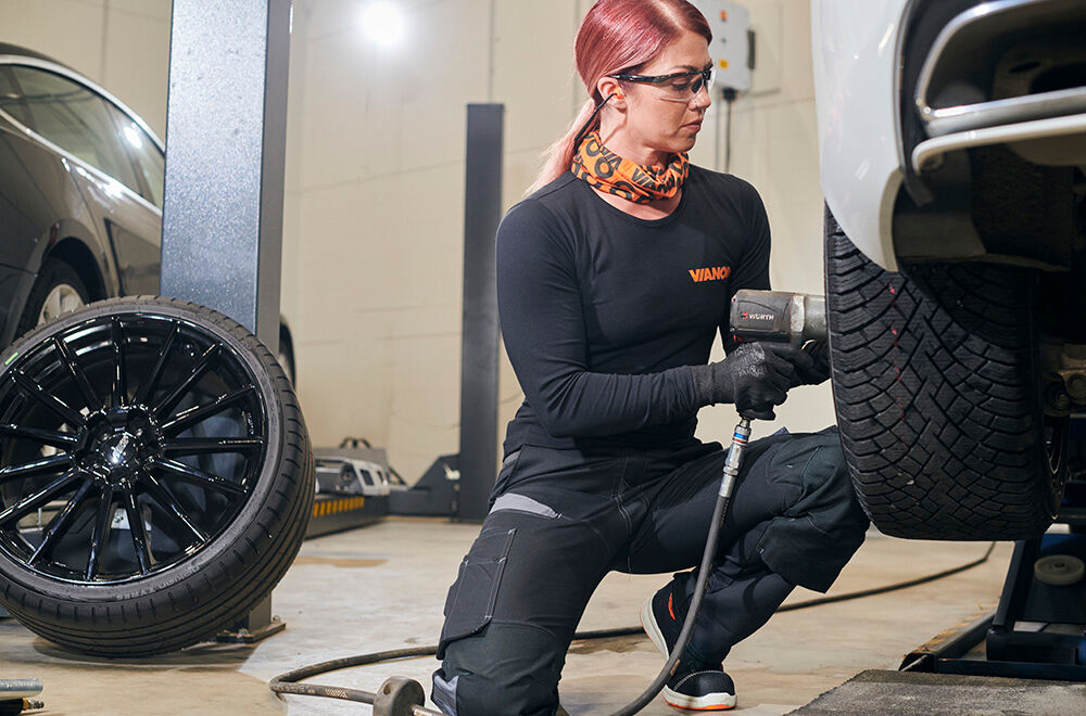 Et dekk med felg bak en dekkmontør